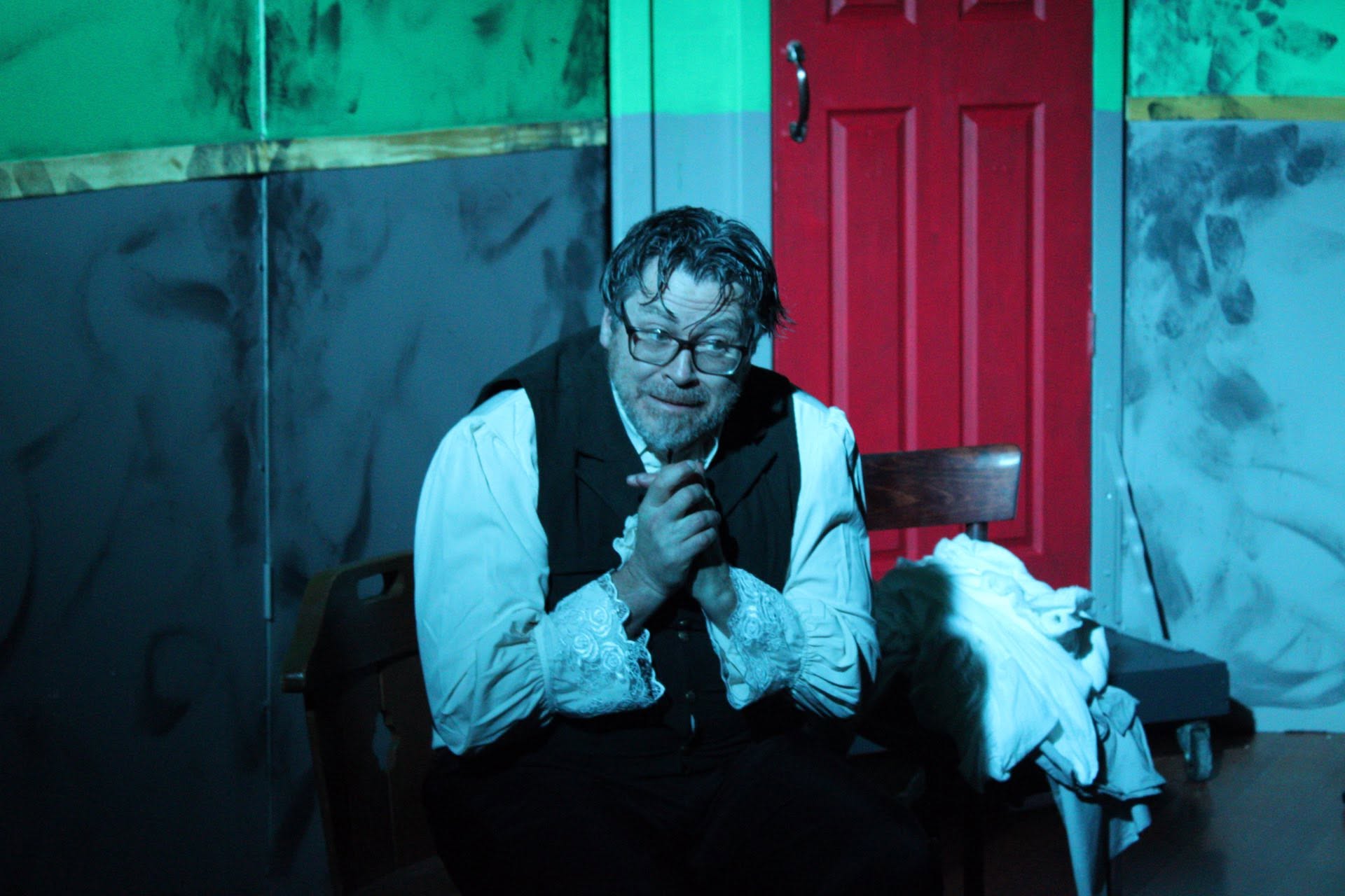 A seated performer bathed in blue light