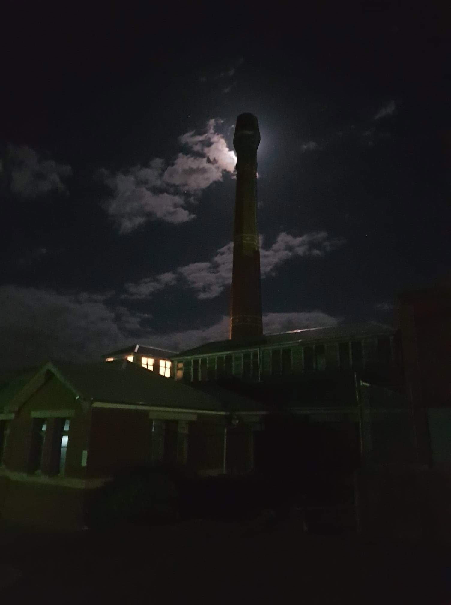 The historic Boilerhouse chimney lit by moonlight in Sunbury